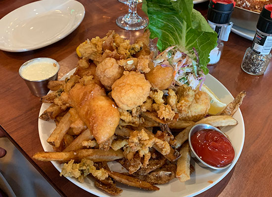 Plate of fried seafood, fries, slaw & sauces at The Grill at Fairview Inn, Marshfield Massachusetts.