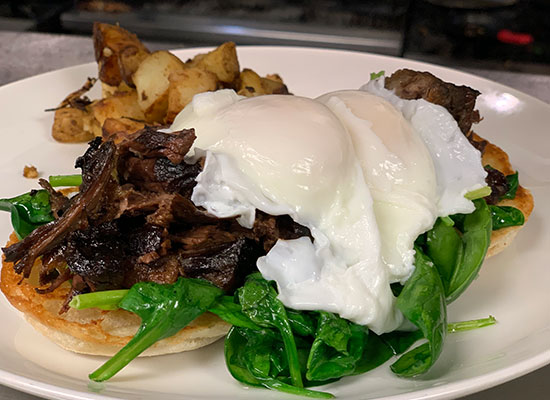 Poached eggs on shredded meat, spinach & bread at The Grill at Fairview Inn Restaurant Marshfield.
